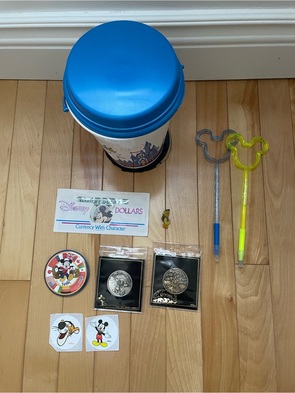 Disney popcorn bucket with lid, Disney coins, and assorted items